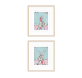 Two framed abstract bunny paintings stacked vertically, featuring pastel blue and pink backgrounds with expressive brushstrokes in a minimalist wood frame.