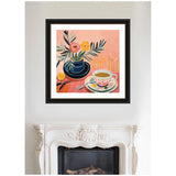 Framed painting above a white ornate fireplace depicts a coffee cup with pink and gold accents beside a blue vase holding pink and yellow flowers against a peach background.