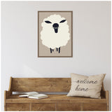 Minimalist framed canvas of a fluffy white sheep with black face and legs on a beige background, hung above a wooden bench with a 'welcome home' pillow and open book.