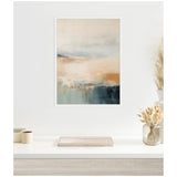 Abstract coastal-themed canvas wall art with soft beige, blue, and gray tones, hung above a white shelf with dried floral arrangements and small containers.