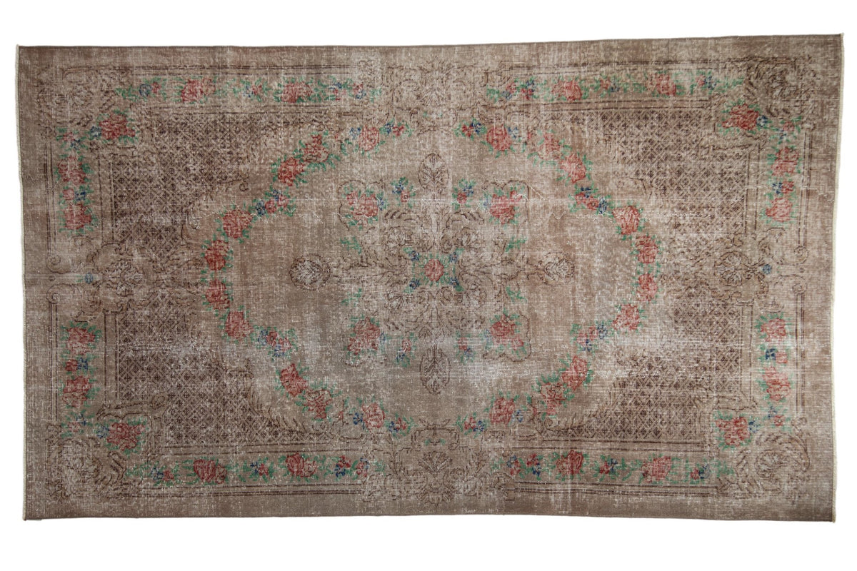 5.5x9.5 Vintage Distressed Overdyed Oushak Carpet featuring a quatrefoil medallion and floral rose borders in silver, mint green, and dusty brick red hues