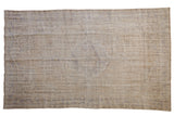 5.5x9.5 Vintage Distressed Oushak Carpet showing floral center medallion and faded colors in ivory, beige, and pale royal blue