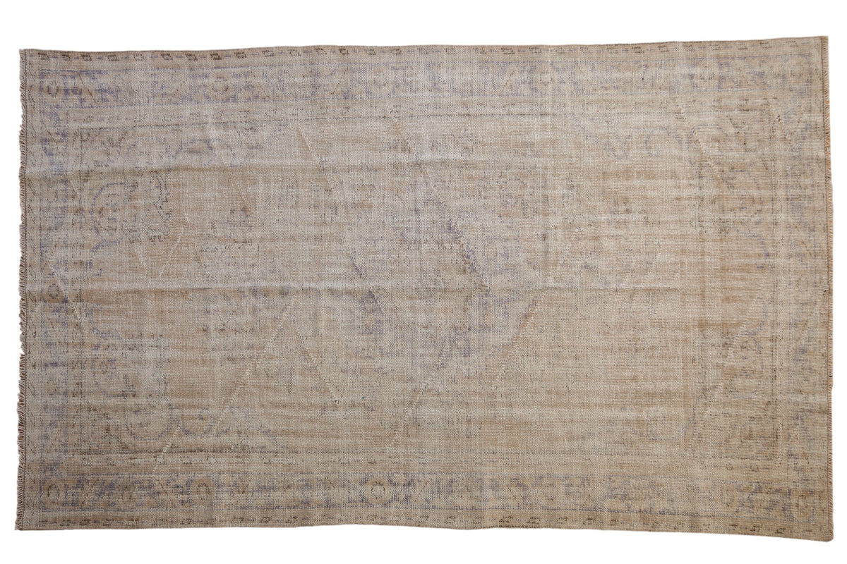 5.5x9.5 Vintage Distressed Oushak Carpet showing floral center medallion and faded colors in ivory, beige, and pale royal blue