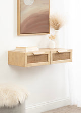 Light wood floating console with two rattan drawer fronts and wooden handles, decorated with white ceramic vases and books beneath a framed abstract painting.