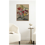 Framed print of Vase avec bouquet de fleurs by Louis Valtat showing a muted palette floral bouquet in a greenish vase against a soft, neutral background, hung on a white wall above a brass round pedestal table between two cream-up