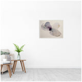 Abstract floral watercolor painting in muted purples and grays on a framed canvas, hung on a white wall above a wooden side table with a green fern in a glass vase.