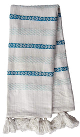 Handwoven white throw featuring alternating turquoise geometric patterned and light blue striped bands, finished with thick white braided tassels on one edge.