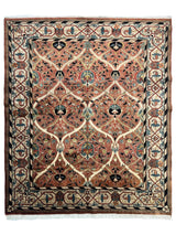 Rectangular hand-knotted wool rug with an interlaced ivory lattice over floral motifs in red, blue, and beige tones, framed by a geometric patterned border.