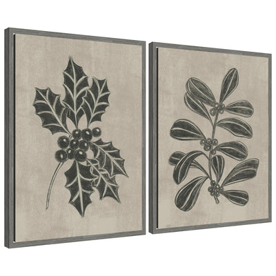 Two framed canvas artworks depicting winter holly leaves and berries in monochrome with textured backgrounds
