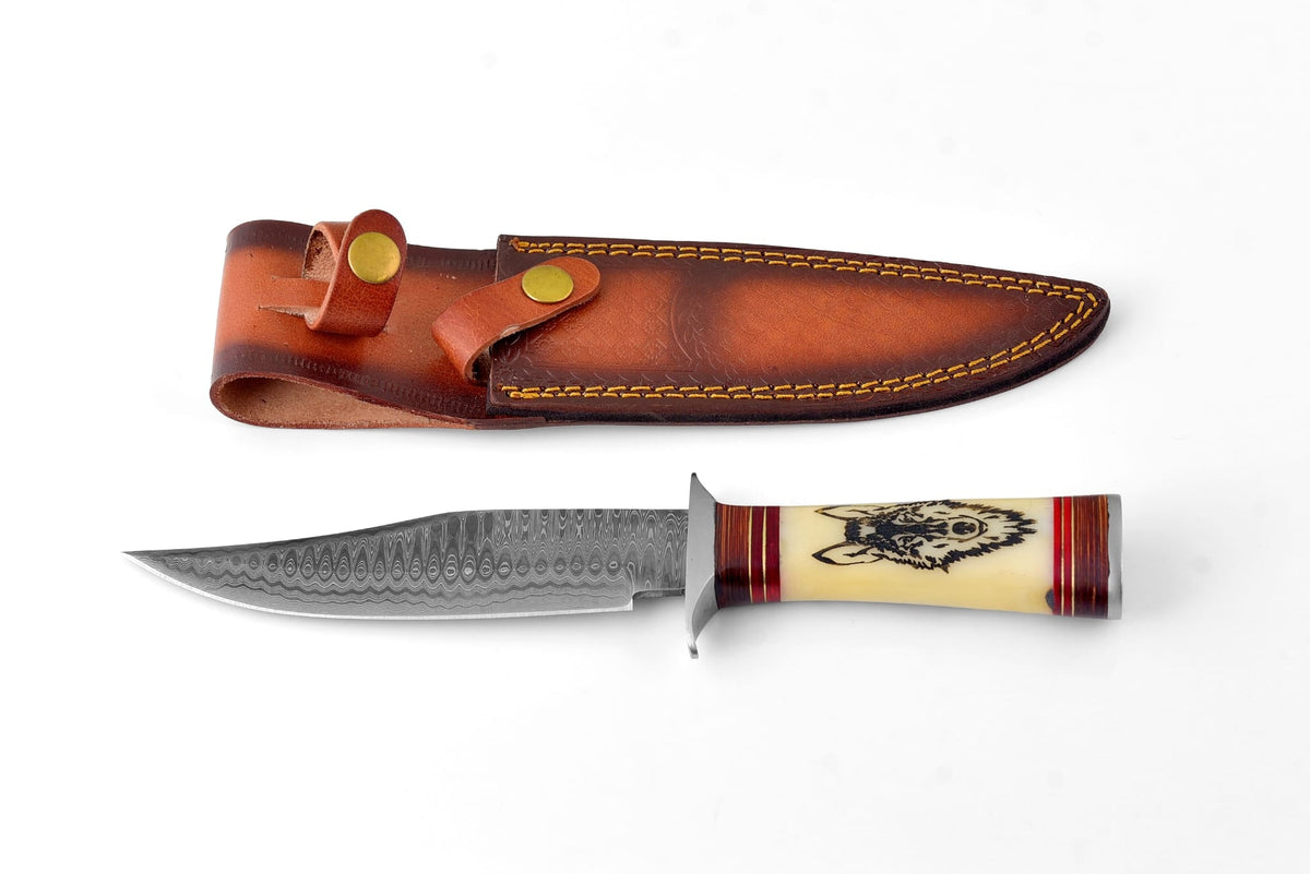 Damascus steel knife with a patterned blade and a cream handle featuring a wolf engraving, accompanied by a brown leather sheath with yellow stitching and brass snap closure.