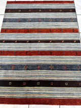 Rectangular striped rug with alternating wide bands of rust red, dark brown, and variegated gray, featuring small geometric and plant motifs in multicolored accents.