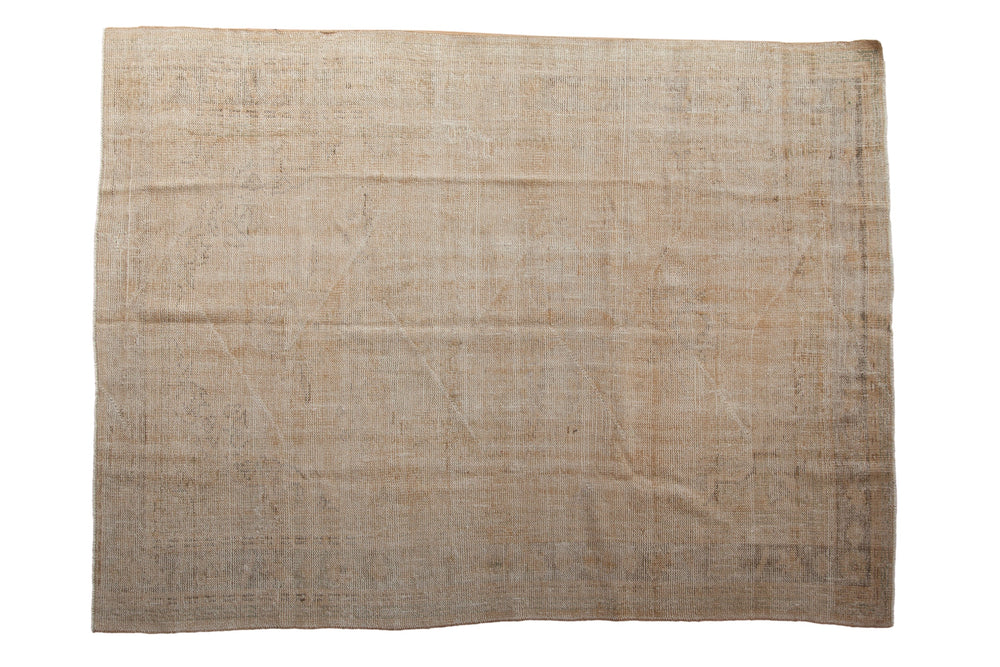Muted beige vintage Oushak carpet with a distressed, faded pattern and subtle tonal variations across the flatwoven surface