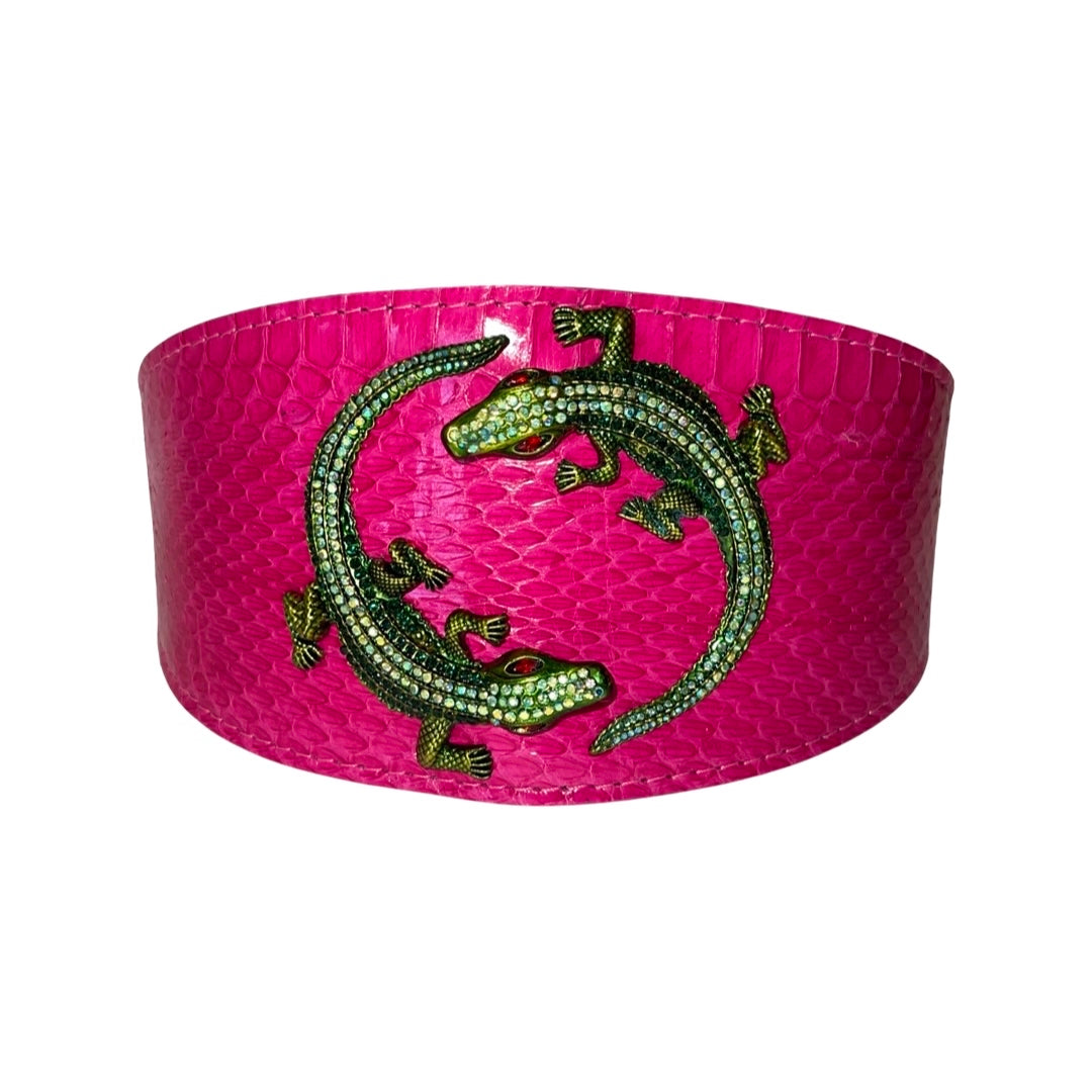 Wide fuchsia pink snake-skin textured collar featuring two green rhinestone alligators facing each other in a circular pattern