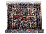 Hand-knotted Afghani Mamluk wool rug with intricate geometric patterns in blue, brown, and cream tones, partially rolled at the bottom showing detailed border design.