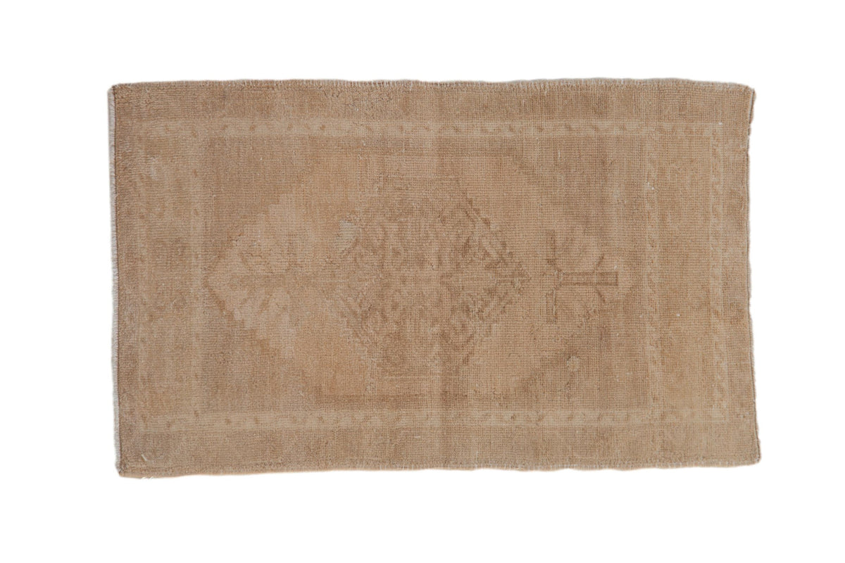 Vintage distressed Oushak rug mat showing center medallion and intricate floral patterns in beige and cream tones