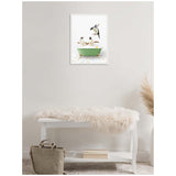 Framed canvas of three penguins in a green bathtub on multicolored tile, hanging on a light gray wall above a white bench with a fur throw and beige bag below.