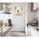 Small white kitchen with gray countertops and appliances, featuring framed canvas artwork of a Highland cow in a white bathtub with palm leaves on the back wall.