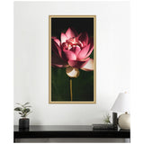 Framed wall art print of a vibrant pink lotus flower with intricate petals, set against a dark green and black background, adding depth and contrast.