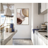 Neutral-toned abstract canvas with overlapping translucent circles in beige, brown, and blush, framed and hung on a white wall in a modern kitchen corner.