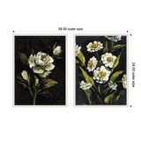 Two framed canvas art pieces featuring light-colored flowers with green leaves on dark moody backgrounds, sized 38 by 24 inches each with a decorative beaded frame.