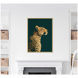 Profile portrait of a gilded cheetah with black spots against a dark green background, framed and hanging above a white fireplace in a modern room.