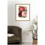 Framed Victorian botanical print of three large roses in red, pink, and dark burgundy with green leaves on a white background, hanging above an olive green armchair.