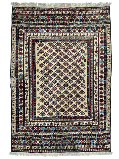 Hand-woven Afghani Maliki Soumak wool kilim rug laid on wood floor, displaying red and cream geometric patterns