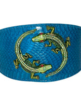 Dark turquoise band with textured snake skin pattern featuring two green rhinestone alligators with red eyes positioned in a circular arrangement
