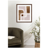 Abstract framed art with intersecting curved white lines over brown and muted mauve rectangular patches, hanging on a white wall above a dark green armchair and woven basket plant.