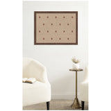 Rectangular beige pinboard framed in dark wood with a repeating red botanical block print pattern, hanging on a white wall above a small brass side table with a white vase.