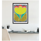 Abstract framed canvas print featuring a large yellow flower with red and pink arches at top, green leaves, and a border of blue dots on white background, hanging above a modern desk.