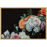 Bouquet of pastel roses, blue hydrangeas, and orange carnations arranged in a glass vase against a dark background with green leafy accents.