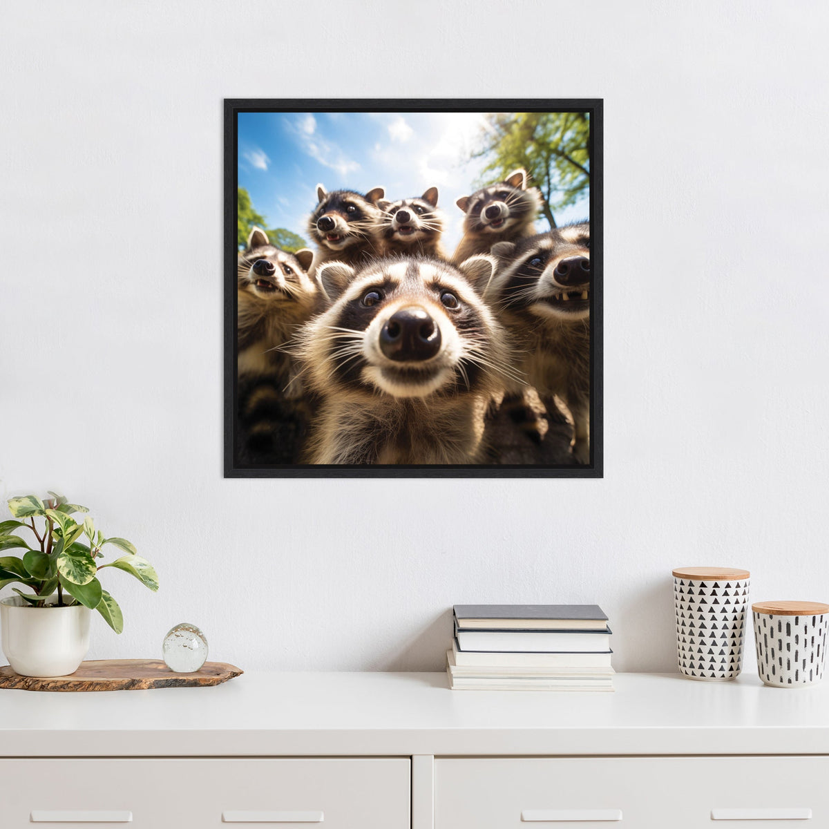 Square wall art showing a close-up of six raccoons with curious expressions under a sunny blue sky framed in simple black.