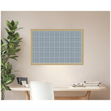 Rectangular framed fabric pinboard with light blue and white plaid pattern hanging on a beige wall above a modern white desk with books and plant.