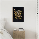 Framed floral canvas featuring cream and pale yellow flowers with green leaves on a dark background, hanging above a rustic wooden side table beside a white bed.