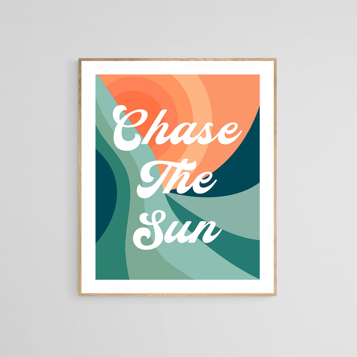 Framed typography print with the phrase 'Chase The Sun' in white script over layered curved shapes in shades of orange, teal, and green.