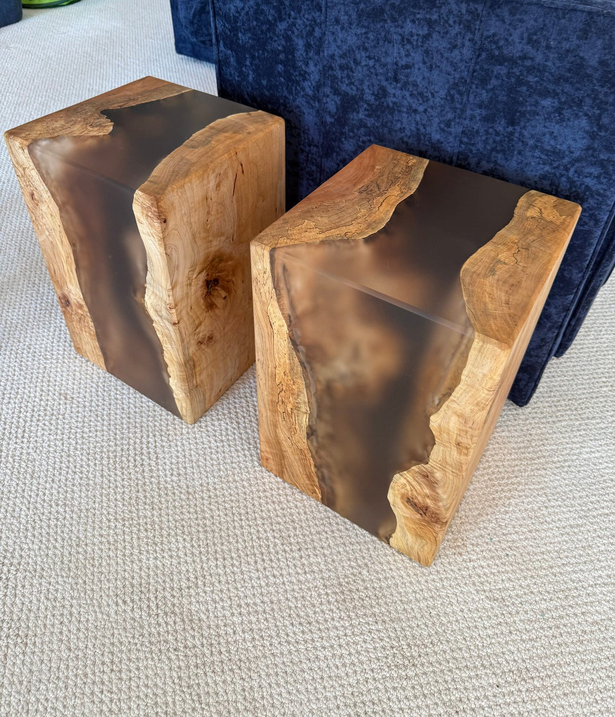 Two wooden side tables with a natural maple finish and epoxy accents on a white background