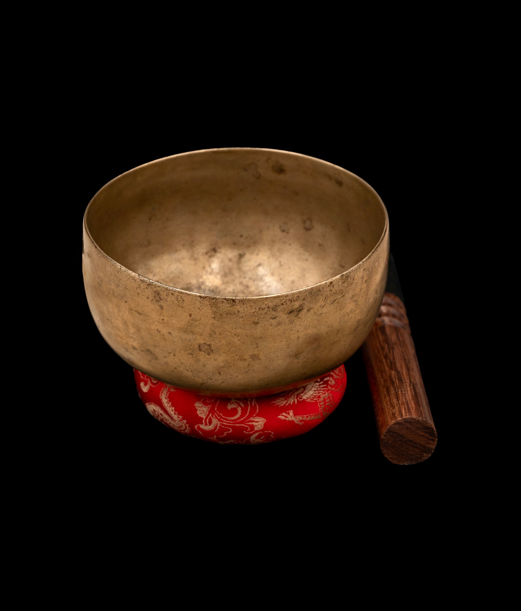 Antique Cup Thadobati Singing Bowl resting on a silk-brocade cushion with leather-padded mallet