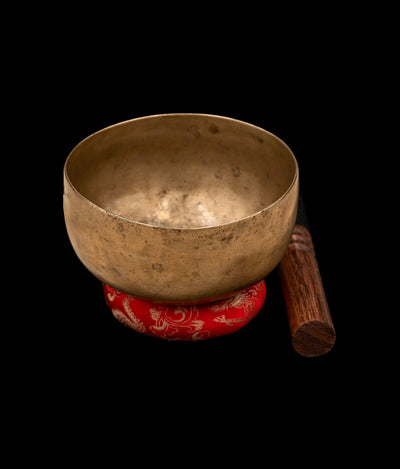 Antique Cup Thadobati Singing Bowl resting on a silk-brocade cushion with leather-padded mallet