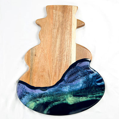 Snowman Resin Charcuterie Board with colorful resin design on acacia wood, displayed on kitchen counter