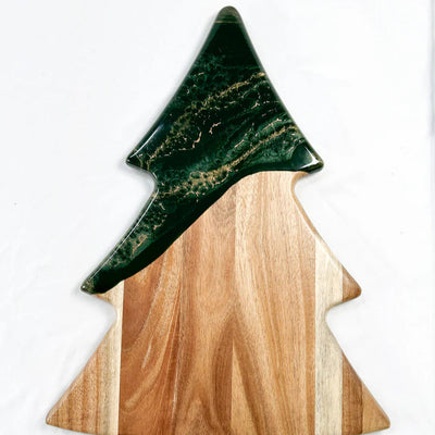 Christmas Tree shaped serving board made of acacia wood with green resin accent, styled with holiday snacks.