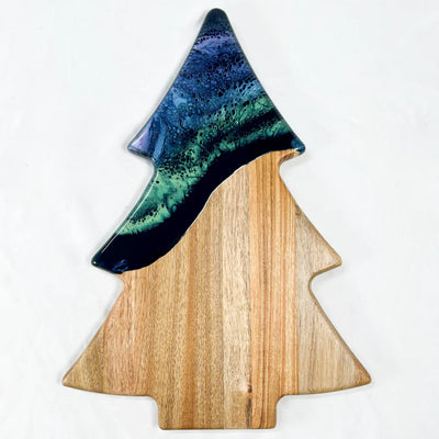 Christmas Tree shaped serving board made of acacia wood with green resin accent, styled with holiday snacks.