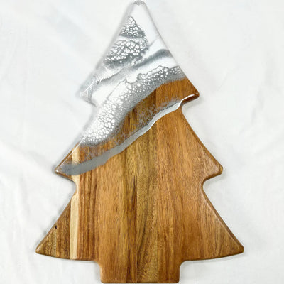 Christmas Tree shaped serving board made of acacia wood with green resin accent, styled with holiday snacks.