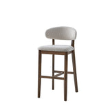 Mid-century modern bar stool with brown solid wood frame and rounded white upholstered backrest and seat featuring textured fabric.