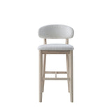 Mid-century modern bar stool with light beige upholstery and natural solid wood frame, featuring a curved backrest and tapered legs with footrest.