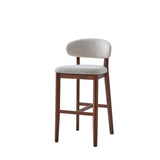 Mid-century modern bar stool with dark wooden legs and frame, featuring light gray upholstered curved backrest and padded seat