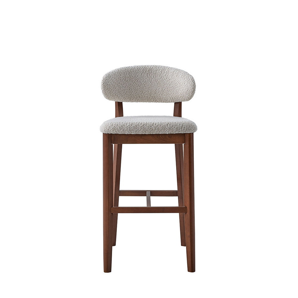 Single mid-century modern bar stool with curved beige upholstered back and seat on solid brown wood legs with horizontal footrest.