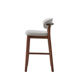 Mid-century modern bar stool with solid wood legs and frame, featuring a curved gray upholstered backrest and matching cushioned seat in bouclé fabric.