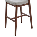 Lower portion of a mid-century modern bar stool with dark brown solid wood legs and a light gray upholstered seat with textured fabric