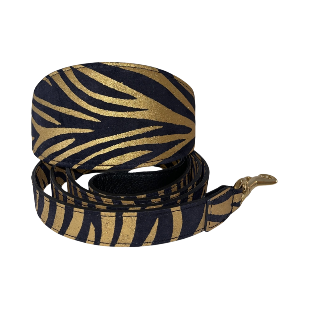 Black and gold zebra print Italian leather dog collar and matching leash with gold hardware, displayed coiled on a white background.